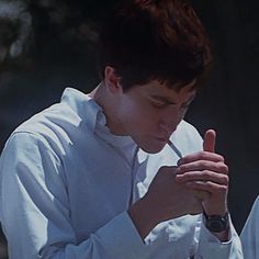 a young man is praying with his hands together