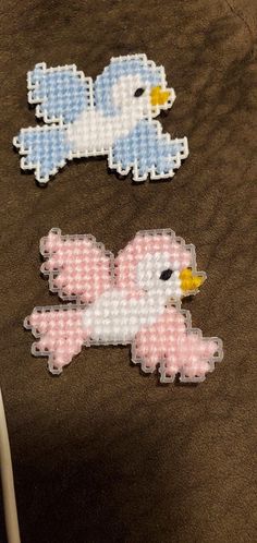 two cross stitch birds sitting next to each other