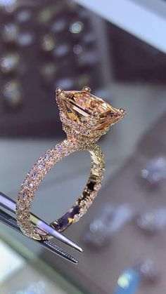 a fancy diamond ring sitting on top of a table