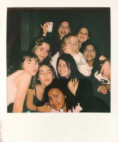 a group of young women posing for a photo in front of a mirror with their arms around each other