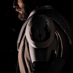 a man wearing a star wars costume in the dark with his back to the camera