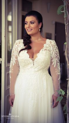 a woman in a wedding dress posing for the camera