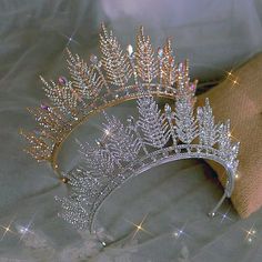 a tiara with crystal leaves on it is sitting on a cloth covered tablecloth