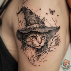 a cat with a witches hat on it's head is shown in this tattoo