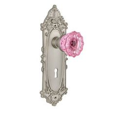 an ornate door handle with a pink flower on it