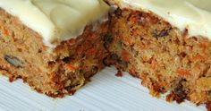 a carrot cake with white frosting on top is cut in half and ready to be eaten