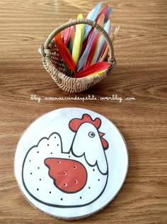 a basket full of colored pencils next to a plate with a chicken on it