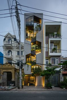 an apartment building with many balconies and plants on the balconys is lit up at night