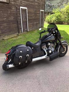 a black motorcycle parked in front of a wooden building