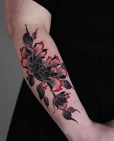 a woman's arm with flowers and leaves tattooed on the left side of her arm