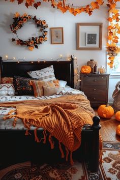 a bedroom decorated for halloween with pumpkins on the bed and decorations hanging from the wall