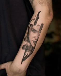 a man's arm with a tattoo on it that has an image of a woman holding a knife