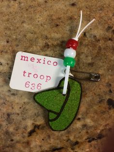 a keychain with a tag that says mexico troop 666 on it sitting on a granite surface