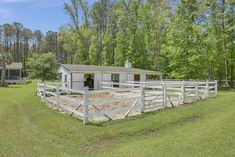 a white horse pen in the middle of a field