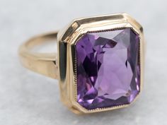 Indulge in luxury with this ring! The bezel setting showcases the stunning emerald cut amethyst, creating a sophisticated and elegant look. Elevate your style and embrace the exclusivity of this solitaire ring. Metal: 10K Yellow Gold Gem: Amethyst 5.68 Carats Gem Measurements: 10.1 x 11.9 mm, Emerald Cut Ring Size: 5.50 Marks: "10K<>" Stamped on the inside band SKU #: A37623 Each piece has been identified and graded by a Graduate Gemologist who has been certified by the Gemological Institute of America (GIA). We have six brick-and-mortar storefronts in Maine, Massachusetts, and New Hampshire and have been in business for over 25 years! Please visit our Shop's About Page or our website for more information about our jewelry. For questions about diamond grading, we recommend the  Gemological Right Hand Ring, Emerald Cut Rings, Pocket Watch Chain, Right Hand Rings, Hand Ring, Ring Metal, Amethyst Ring, Pearl Pendant, Bezel Setting