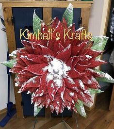 a large red and white poinsettia in front of a blue cabinet with the words knoll's kraffe on it