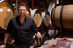 a man standing in front of some wine barrels