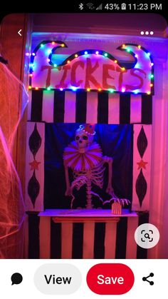 a fake skeleton sitting in front of a ticket booth