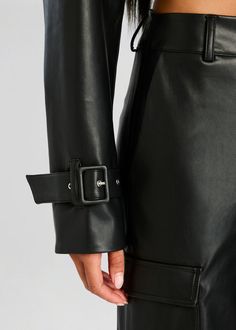 Cropped vegan leather jacket with adjustable buckle cuffs. Shown here in Black. Face: 100% Polyurethane Back: 100% Polyester Made in China Model is 5'10" wearing size S Style No. 4434-19 Chic Leather Jacket With Belt For Work, Leather Jacket With Belted Cuffs, Fitted Faux Leather Belted Outerwear, Spring Leather Jacket With Belted Cuffs, Spring Leather Jacket With Belted Cuffs And Long Sleeves, Chic Leather Jacket With Belted Cuffs, Chic Leather Jacket With Belted Cuffs For Work, Fitted Leather Jacket With Belted Cuffs, Chic Fitted Leather Jacket With Belt Loops