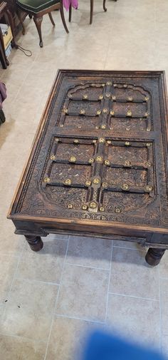 an old wooden table sitting on top of a tiled floor