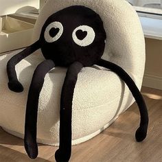 an octopus stuffed animal sitting on top of a white chair in front of a window