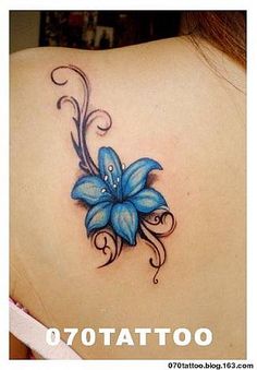 a blue flower tattoo on the back of a woman