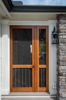 the front door to a house with brick pillars and glass panels on it's sides