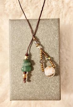 This lovely string bookmark is approximately 10 inches and is a beautiful yet functional piece to add to all your bookish decor. This piece of book jewelry is made with brown waxed string so it will withstand many years of frequent use. Multi-faceted glass beads with gold-tone accent beads accompany this piece.   Green adventurine is a stone of growth, aligns with the heart chakra. This stone helps open your heart to receive blessings manifesting abundance and good fortune.  Materials:  -0.65mm brown waxed ramie cord -Metal & glass accent beads -Green adventurine stone chips Note: All of my items are created by hand and shipped from a smoke-free home. Please allow for slight variations! Buyers are welcome to reach out to seller before purchase with any concerns. Brown Lariat Beaded Necklace For Gift, Brown Lariat Beaded Necklace Gift, Earthy Adjustable Beaded Necklace For Gifts, Earthy Adjustable Crystal Necklace For Healing, Bohemian Beaded Necklaces With Waxed Cord As Gift, Adjustable Crystal Long Necklace For Gift, Adjustable Long Crystal Necklace For Gift, Adjustable Long Crystal Necklace Gift, Adjustable Brown Crystal Necklace For Healing