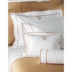 white and gold bedding set with embroidered monogrammed pillowcases on top