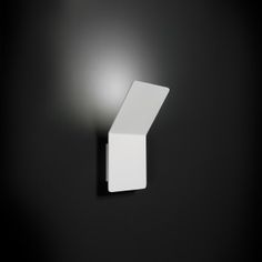 a black and white photo of a light fixture on the side of a wall in a dark room