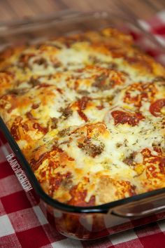 a casserole dish with meat and cheese on a red checkered tablecloth