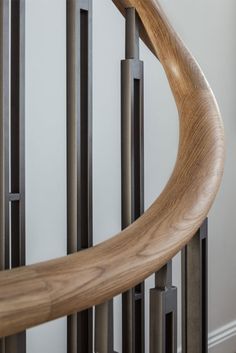 a close up view of a wooden and metal stair rail with handrails in the background