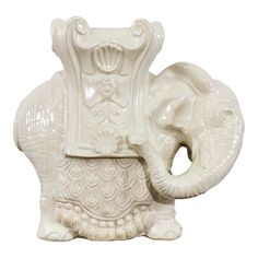 an elephant statue sitting on top of a white table