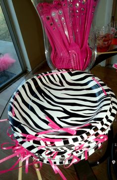 zebra print plates with pink bows on them and a glass vase in the back ground