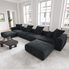 a living room filled with black couches and white carpeted flooring next to windows