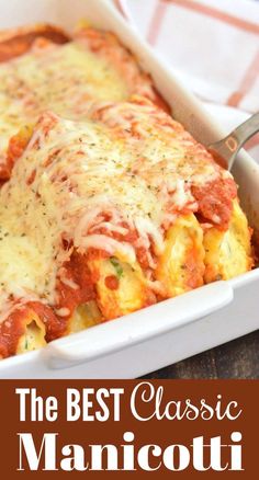 a casserole dish with cheese and sauce in it on a wooden table next to a fork