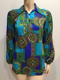 "This is a fun vintage shirt from the 1960'70's era by Mardi Modes New York. Bright paisleys in shades of royal blue, lime green, purple, turquoise. Pointy collar with 2 buttons for front closure of the keyhole opening. The elastic at the cuffs had been replaced but the person didn't reseam the area as you will see in the photos. When wearing the blouse, it isn't visible but you may want to finish the work. The rest of the blouse is with no obvious issues and gentle vintage wear. The fabric is a Retro Shirt With Vibrant Spring Print, Hippie Patterned Printed Blouse, Blue Long Sleeve Tops With Retro Print, Blue Long Sleeve Top With Retro Print, Retro Long Sleeve Top With Retro Print, Vintage Multicolor Retro Print Blouse, Retro Patterned Tops With Vibrant Print, Multicolor Vintage Blouse With Retro Print, Retro Green Printed Blouse