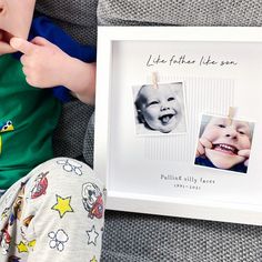 a baby is laying down next to a picture frame with an image of a smiling child