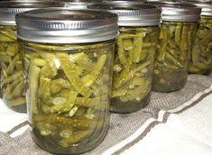 several jars filled with pickles sitting on top of a table