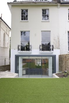 a large white building with two windows on the top floor and an open front door