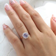 a woman's hand with a ring on it and a diamond in the middle