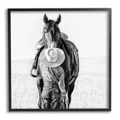 a black and white photo of a horse with a cowboy hat