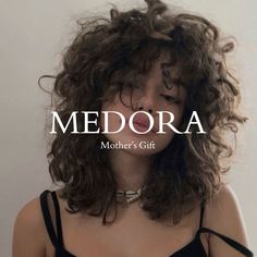 a woman with curly hair is wearing a black top and has the words medora on it