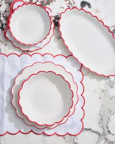 four red and white plates sitting on top of a marble counter