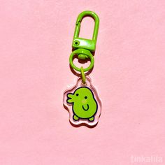 a green plastic keychain with a cartoon character on it's front end