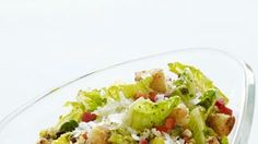 a salad with lettuce and croutons in a glass bowl