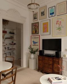 a living room filled with furniture and pictures on the wall above a flat screen tv