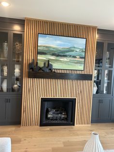 a living room with a painting on the wall and a fire place in front of it