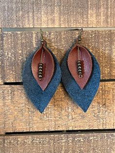 two pairs of earrings with beads hanging from them on a piece of wooden planks