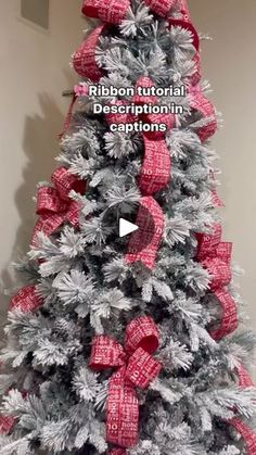 a christmas tree decorated with red and silver ribbon, bows and ribbons on the top